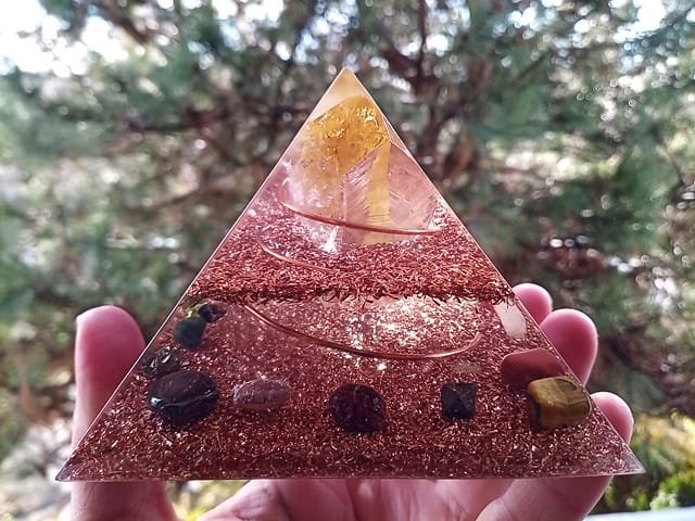 Abundance orgone generator in front of a tree.