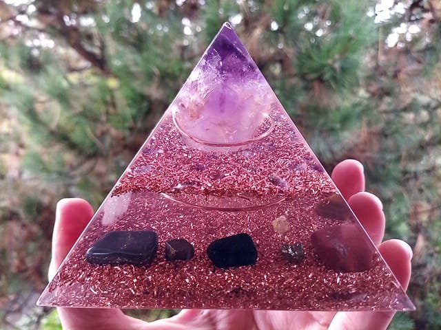 Amethyst orgone pyramid with black tourmaline and hematite grounding stones.