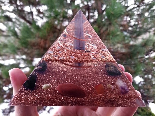 Blue kyanite orgone pyramid in front of pine tree