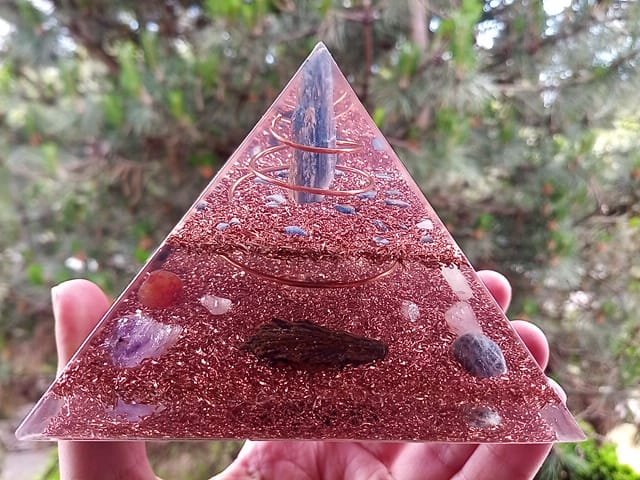 Blue kyanite orgone energy pyramid with black kyanite blade and amethyst crystal.