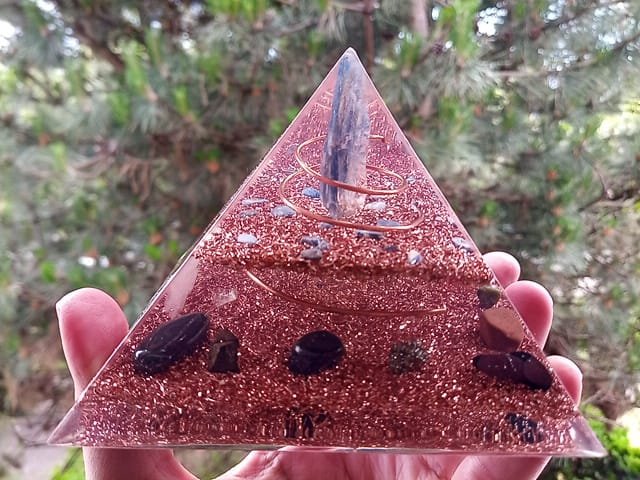 Blue kyanite orgone pyramid with black tourmaline and hematite grounding stones.