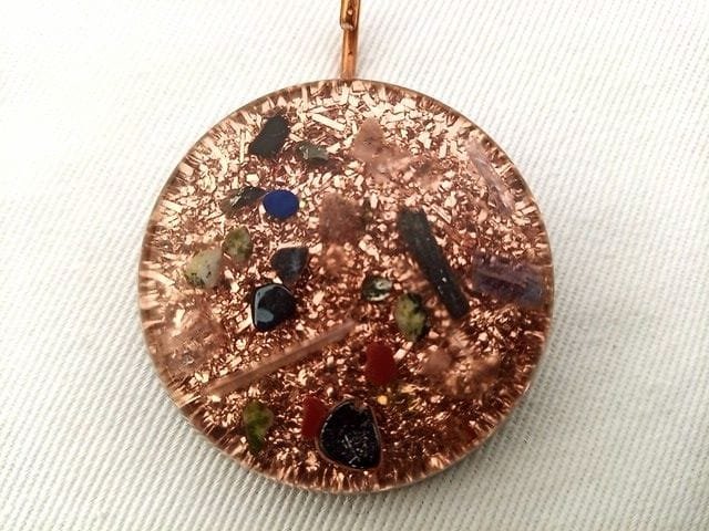 Clear orgone pendant with black tourmaline and shungite crystals on white cloth