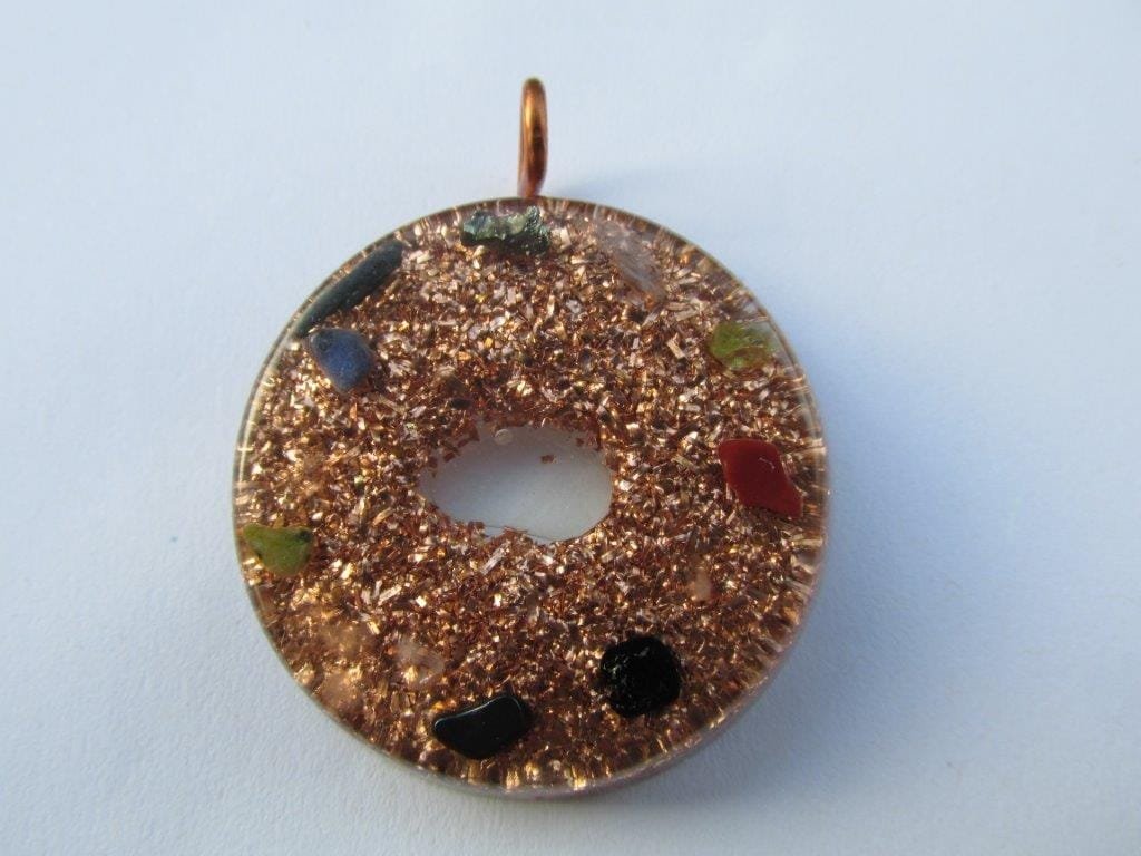 Clear tasmanian energy vortex orgone pendant with black tourmaline on white cloth