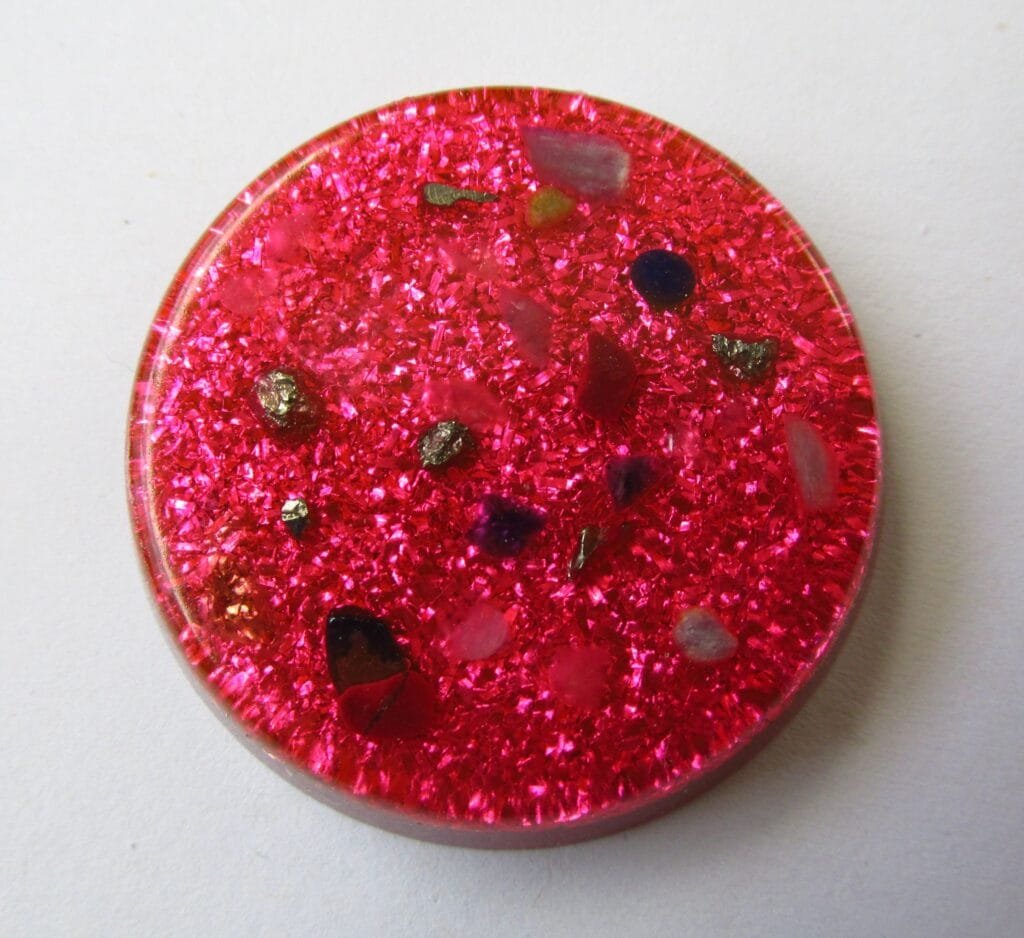 Pink Divine Love orgone disc with rose quartz on a white background