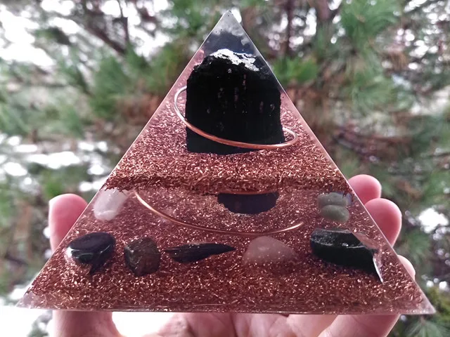 EMF orgone pyramid with pyrite, hematite, obsidian and black kyanite crystals.