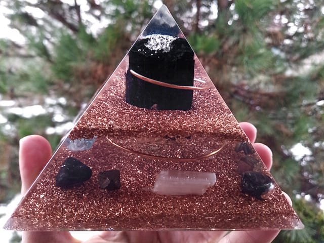 EMF orgone pyramid made with clear resin and copper with grounding stones.