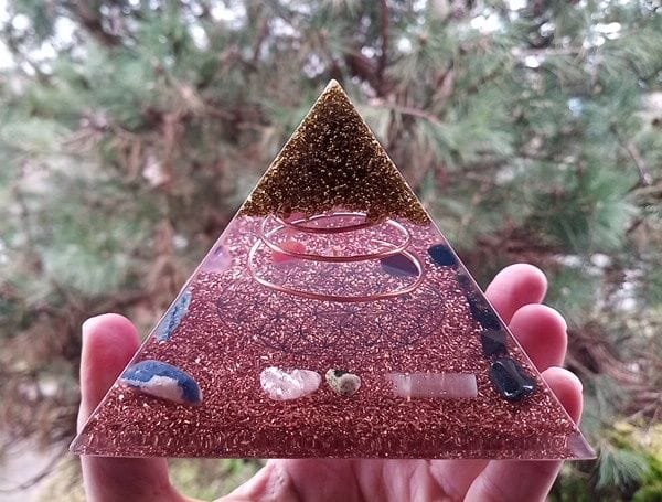 Flower of Life orgone pyramid with rose quartz and selenite crystals inside.