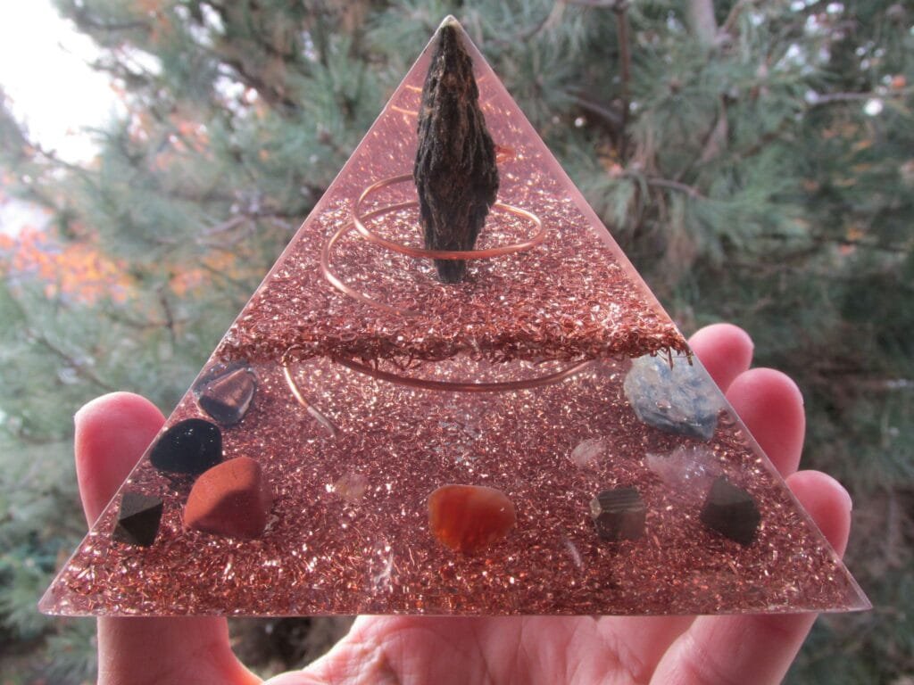 Grounding Orgone Pyramid with grounding crystals in front of tree.