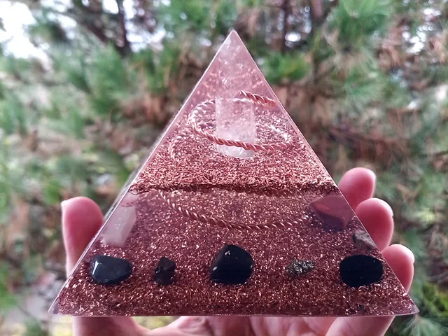 Lemurian Seed Crystal orgone energy pyramid in front of a pine tree.