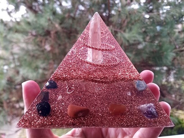 Lemurian Seed Crystal orgone pyramid with red jasper and carnelian in front of a tree.