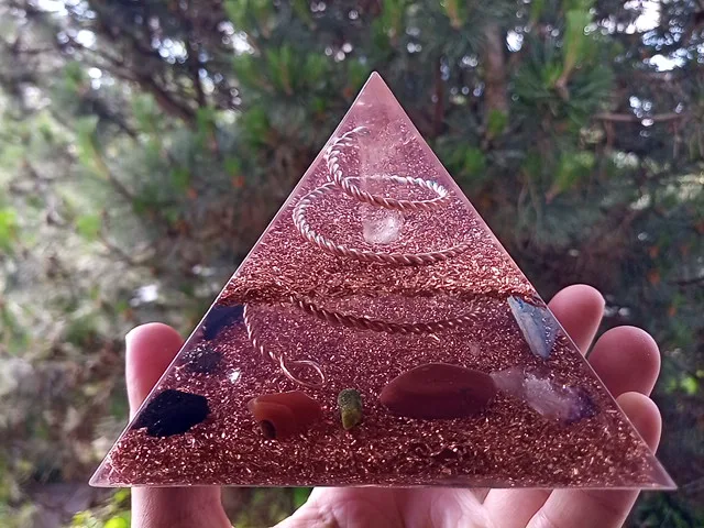 Lemurian Seed Crystal orgone pyramid with red jasper and carnelian in front of a tree.