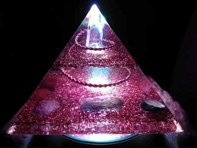 Lemurian Seed Crystal orgone pyramid on top of an led light stand.