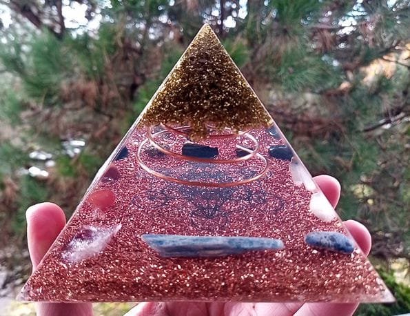 Metatron's Cube Orgone Pyramid, held in front of a pine tree.