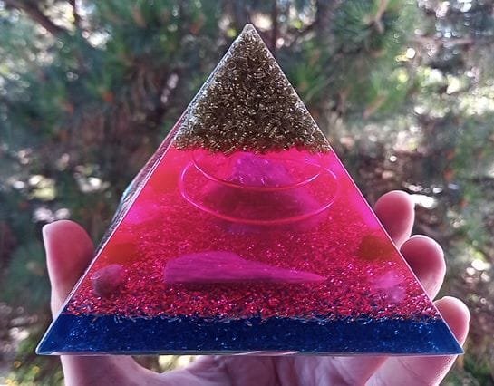 St. Germain orgone pyramid with blue kyanite crystal and amethyst in front of a tree.