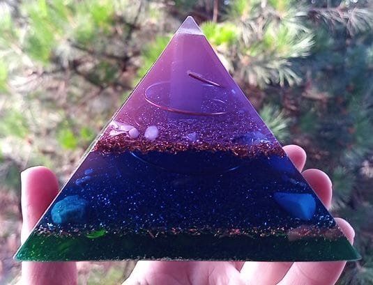 Upper Chakra Orgone Pyramid with copper, violet colored resin and crystals.