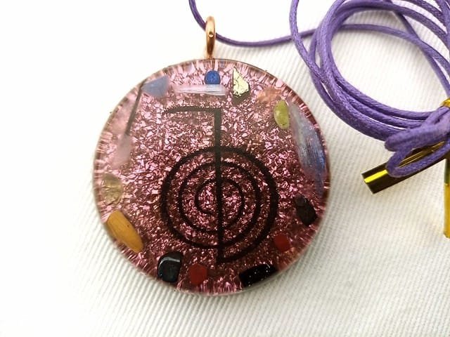 Violet reiki orgonite pendant with blue kyanite and selenite crystals and a violet string.