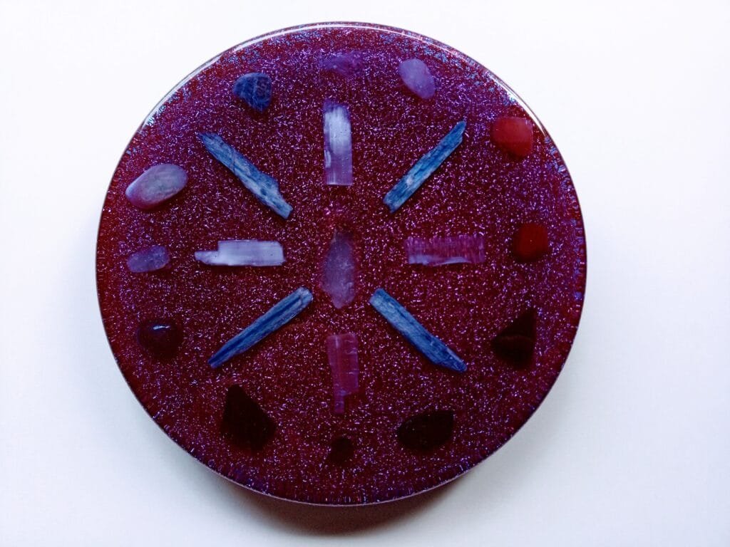 Violet Charging and Clearing Plate with crystals embedded in it on a white background