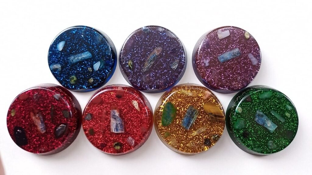 Orgone Chakra Discs in seven different colors on a white background