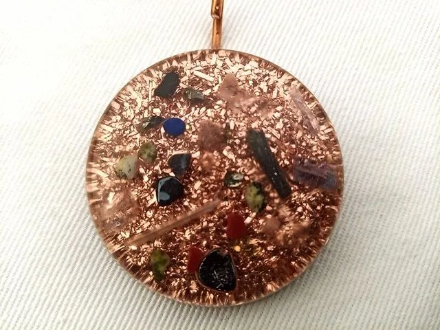 Clear orgone pendant with black tourmaline and shungite crystals on white cloth