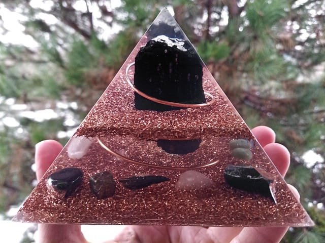 EMF orgone pyramid with pyrite, hematite, obsidian and black kyanite crystals.